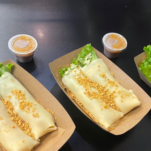 Two servings of Lumpia House fresh lumpia with crushed peanuts, lettuce, and dipping sauce.
